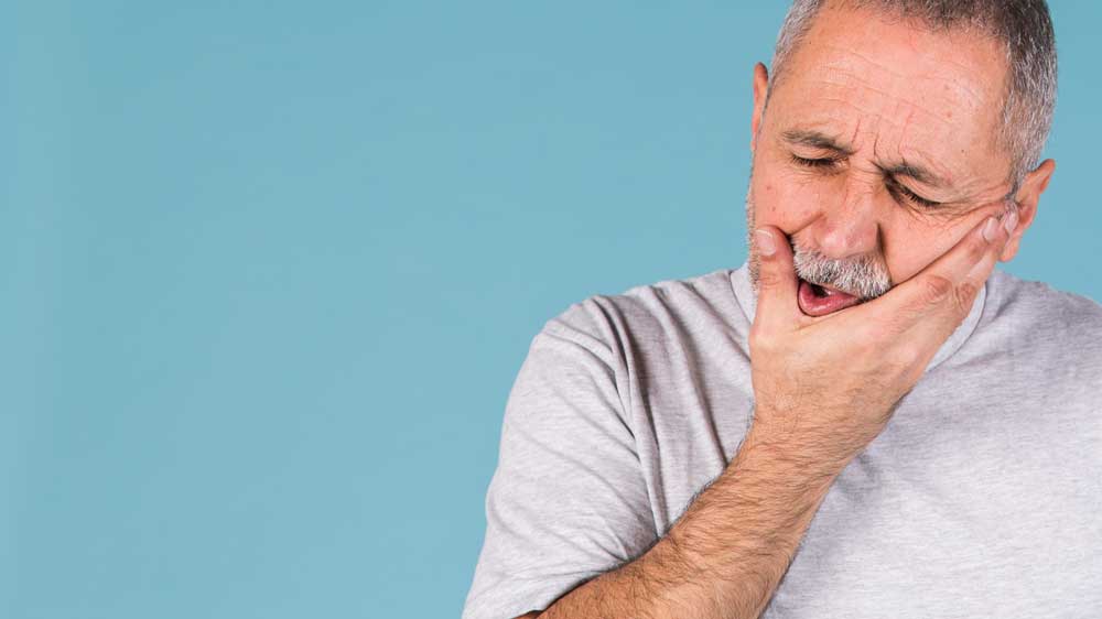 A man holding his jaw.